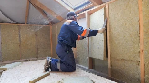 Insulation of a frame house with mineral wool. Cutting, fitting, laying 動画素材 329068704