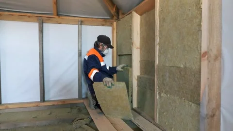 Insulation of a frame house with mineral wool. Cutting, fitting, laying 動画素材 330129126