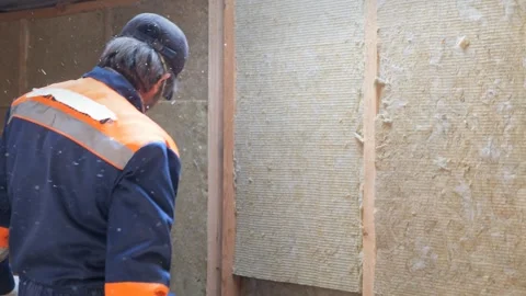 Insulation of a frame house with mineral wool. Cutting, fitting, laying Vidéo 330493802
