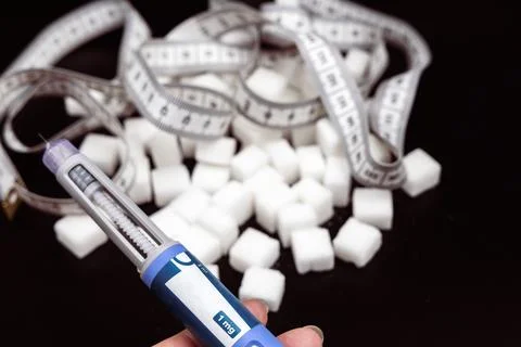 Insulin injection pen on a dark background for diabetics and weight loss. Stock Photos
