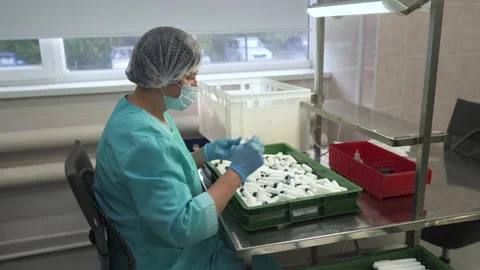 Insulin pen manual assembly process. Female worker inserting cartridges. Factory Stock Footage 150712041