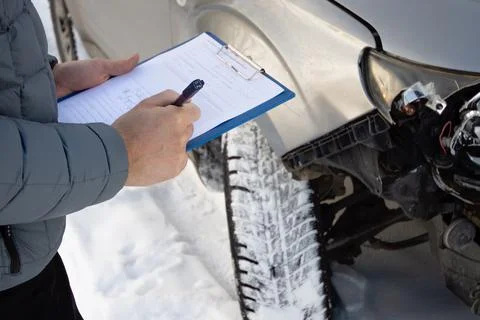 Insurance agent checking car after car accident and filling accident details Stock Photos