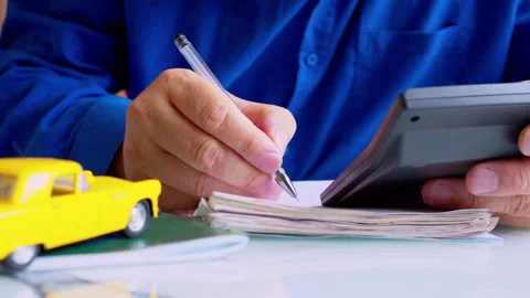 Insurance agent hands using calculator and writing in policy document Stock Footage 337671401