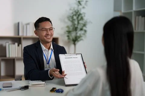 Insurance Agent Presenting Policy to Client in Modern Office. Stock Photos
