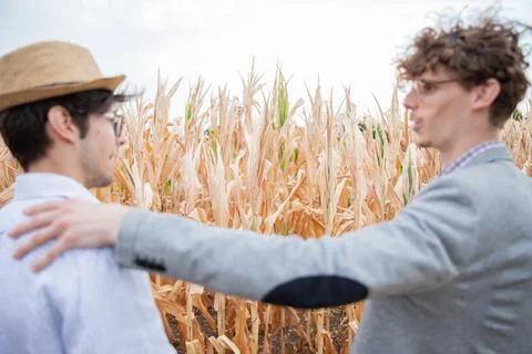 An insurance agent talking to a farmer in the fields, focus on the fields, .. Stock Photos