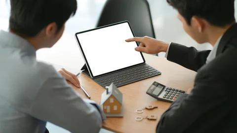 Insurance agents with tablet are introducing real estate insuran Stock Photos