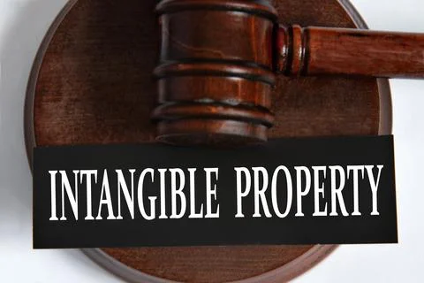 INTANGIBLE PROPERTY - words on a black sheet against the background of a judg Stock Photos