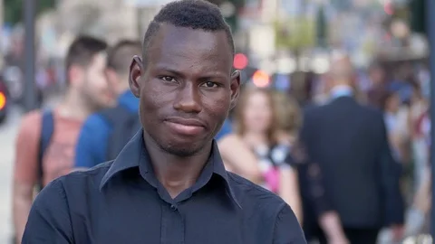Integration, multiculture, ethnicity. black man staring at camera in the city Stock Footage 92777274