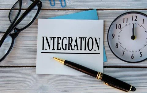 INTEGRATION - word on a white sheet on a light wooden background with an al.. Stock Photos