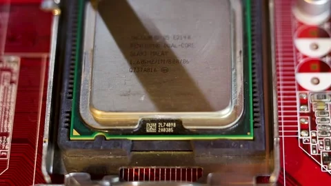 Intel Pentium Dual Core CPU being installed into a red motherboard socket Vidéo 345857207