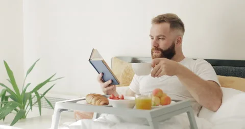 Intellectual man in middle 30s reading while drinking coffee . Good looking Stock Footage 130208569