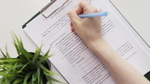 Intellectual property assignment agreement, hand fills out a document, trad.. Stock Footage 276694502