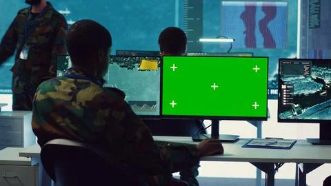 Intelligence analyst reviews ships activity next to an isolated mockup screen Stock Photos