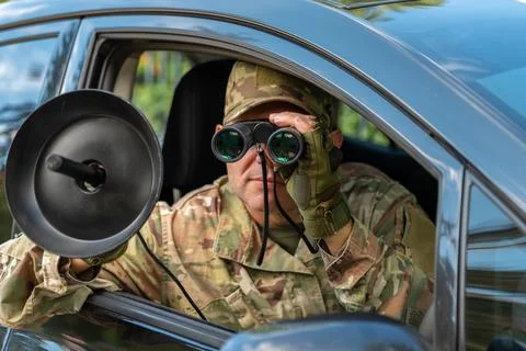 Intelligence operative works from a vehicle while visually tracking a targe.. 库存照片