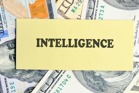 INTELLIGENCE text written on yellow paper on the background of banknotes. F.. 库存照片