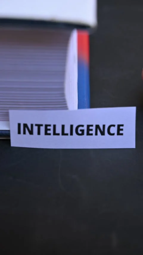 Intelligence Word on Paper Note with Hand and Book in Vertical Close Up Stock Footage 336880859