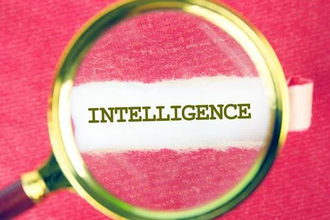 INTELLIGENCE word was found using a magnifying glass under a piece of paper Stock Photos