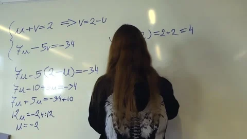 Intelligent female student solving a math equation on a whiteboard Stockbeeldmateriaal 345479003
