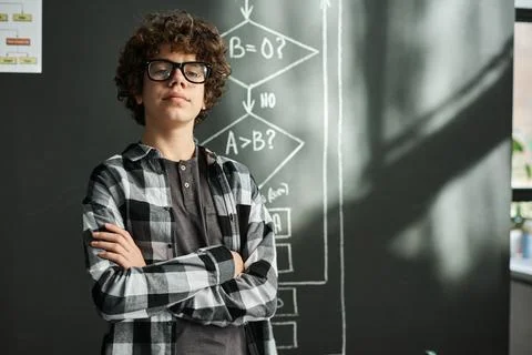 Intelligent schoolboy standing at classroom Stock Photos