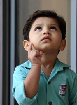 An intelligent toddler is thinking. Curious about. Wondering, solving puzzle Stock Photos