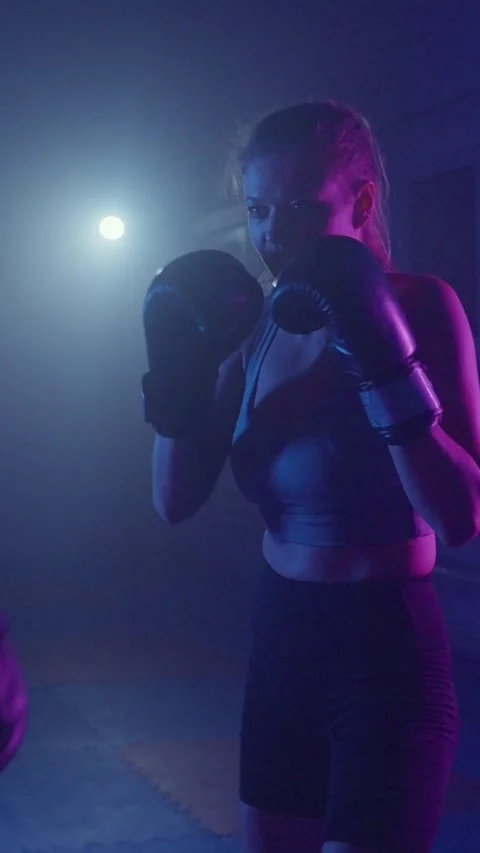 Intense boxing training under vibrant lights showcasing skills and determination Video stock 287283344