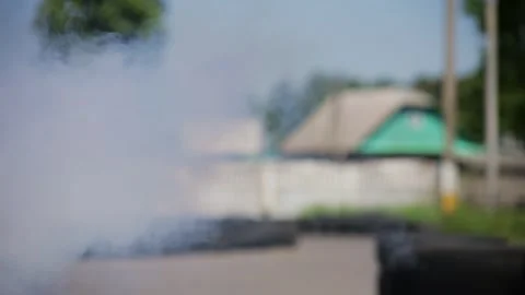 Intense close-up on a kart driver engulfed in thick smoke. The racer grips the Stock Footage 323365762