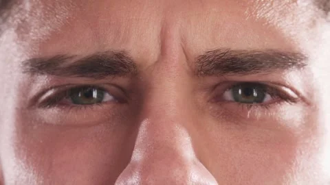 Intense close-up of a young man's emerald eyes in a serious expression Stock Footage 311990833