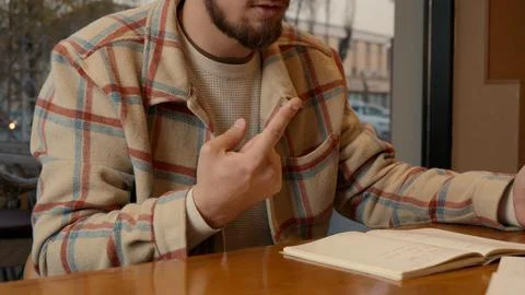 Intense discussion between two students over a table in a warm cafe Foto stock