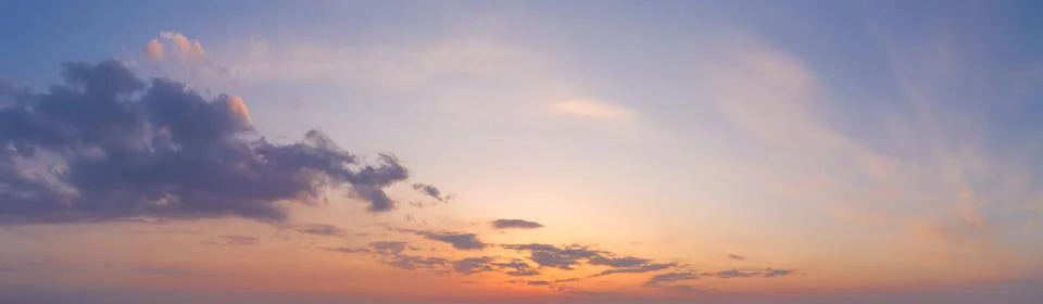 Intense dramatic panoramic sunset with cirrus clouds illuminated by red sunbe 写真素材