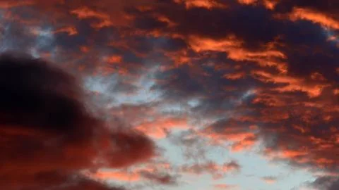 Intense dramatic sky at dusk featuring a striking contrast between glowing Stock Photos