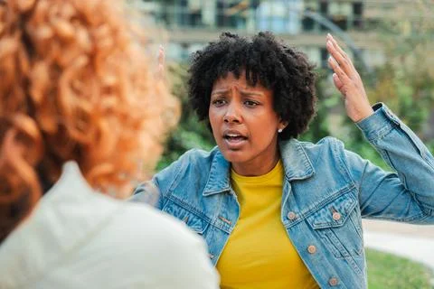 Intense emotional conversation between two women expressing frustration and Stock Photos