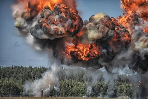 Intense explosion with fire and black smoke and sky in the background Stock Photos
