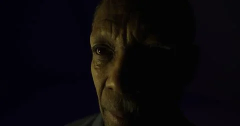 Intense expression of an elderly man during a low light portrait session 스톡 일러스트