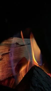 Intense fire close-up featuring bright orange and subtle blue flames licking Stock Photos