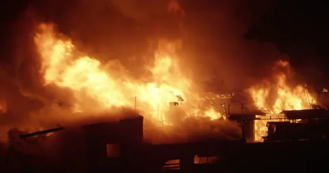 Intense fire inferno in poor settlement with flames in the night sky Video stock 65786631