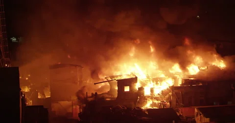 Intense fire inferno in poor settlement with flames in the night sky Stock Footage 65792122