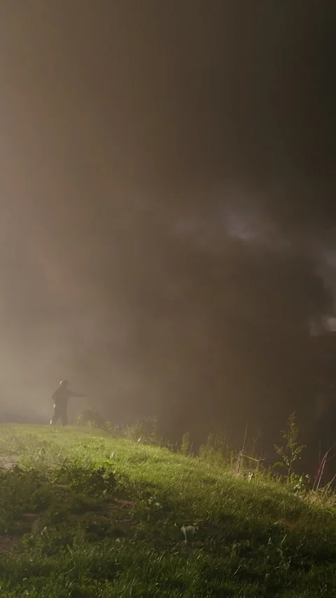 Intense fire scene with thick smoke billowing over green grass, creating a Video stock 313926971