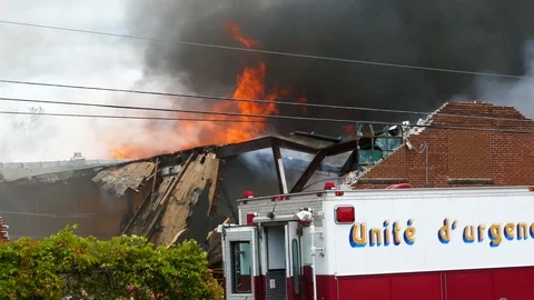 Intense flames rising up from a very damaged building in debris Vidéo 97683174