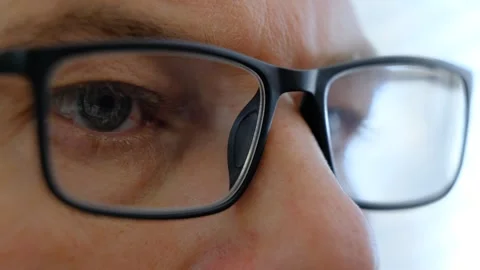 Intense focus on a persons eyes showcasing green reflections while engaging with Stock Footage 315338297