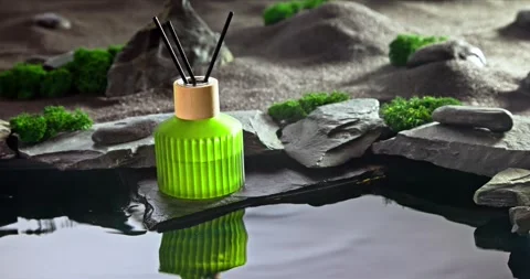Intense fragrance diffuser on black stones illuminated by moonlight. Vidéo 335108777