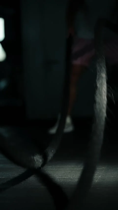 Intense low-light gym training sequence showing a focused athlete driving heavy Stock-Footage 329557878