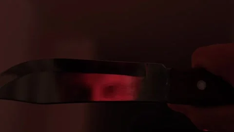 Intense man staring at a knife blade in extreme close up, suggesting dangerous Видео 347300046