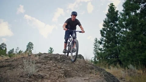 Intense mountain biker rides down steep rock cliff 库存影片 212164754