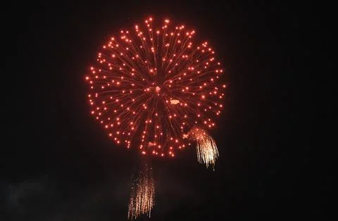 Intense red firework sphere over darkness Stock Photos