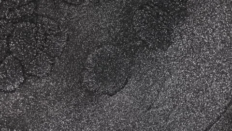 Intense shot of dark titanium paint separating and expanding into large cellular Stock Footage 327605383