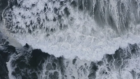 Intense slow-motion waves crash to shore after storm, top down aerial Stock Footage 112703336