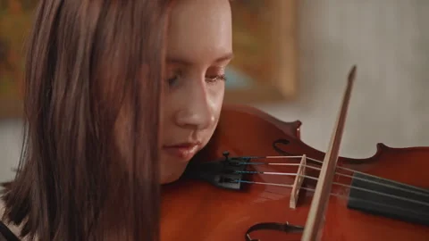 Intense violin practice with focused gaze, dramatic close framing, dynamic Stock Footage 346561964