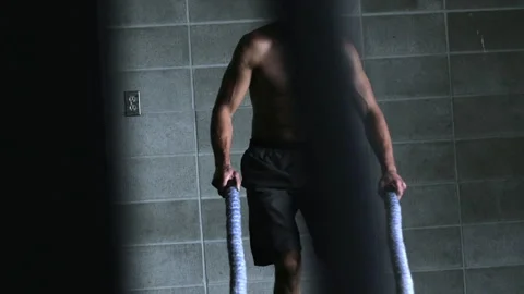 Intense workout with ropes at gym featuring man exercising vigorously Stock Footage 312767595