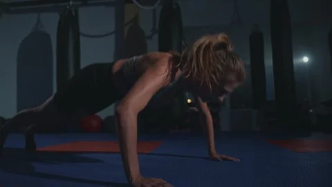Intense workout session at a dimly lit gym focusing on strength training Stock Footage 283470263