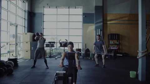 Intense workout sessions in small gym among diverse fitness enthusiasts Stock Footage 312705096